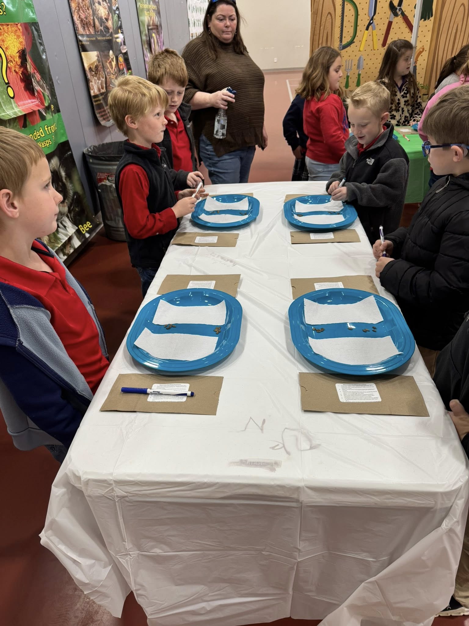 Kids standing around long table.